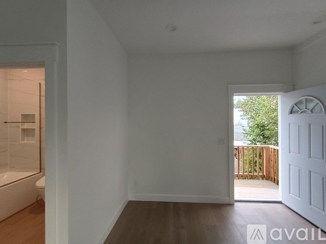 A white room with a door leading to a balcony.