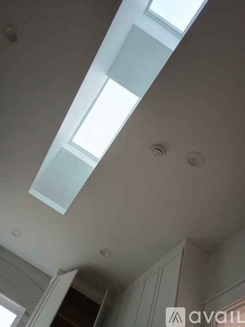 A white ceiling with skylights and a logo that reads "avail".