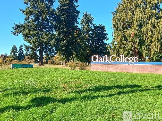 A green field with trees and a sign that says Clark College.