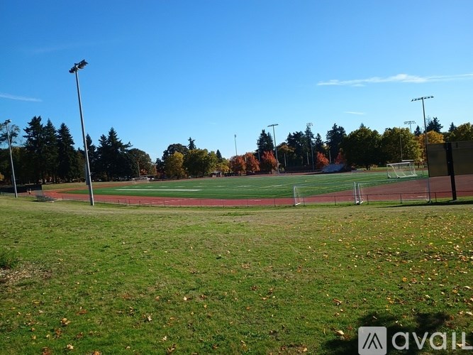 A soccer field with a goal post and trees in the background.