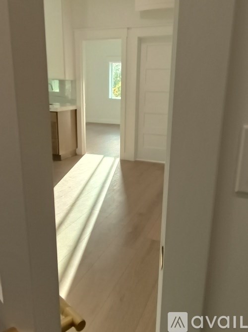 A hallway with a door on the right and a window on the left.