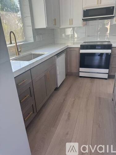 A kitchen with a stove top oven and a sink.
