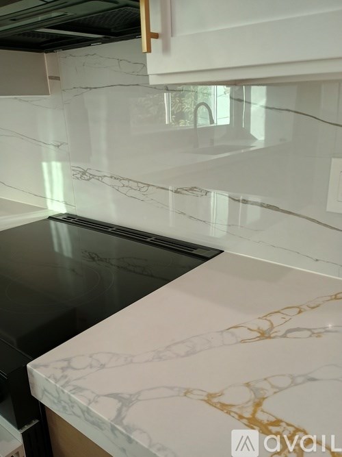 A kitchen counter with a white and gold marble pattern.