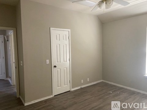 A room with a door and a fan on the ceiling.