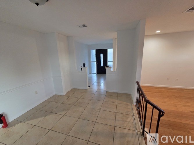 A spacious room with a tiled floor and a doorway leading to another room.
