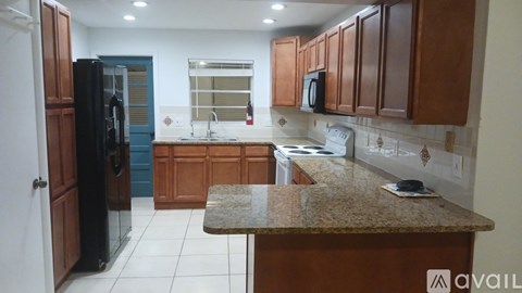 A kitchen with wooden cabinets and a granite countertop.