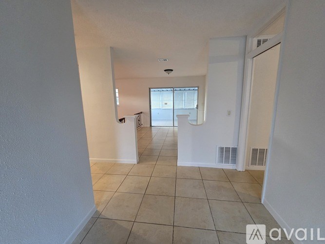 A spacious room with tiled flooring and white walls.