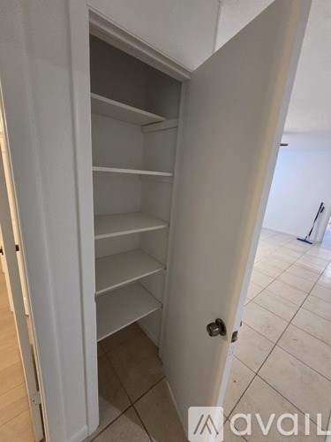 A white door with a shelving unit inside.