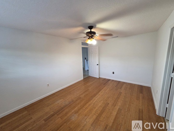 A room with wooden floors and a ceiling fan.