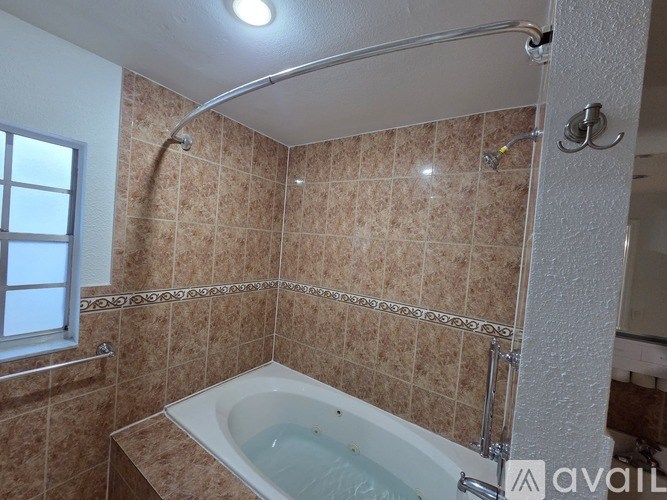 A bathroom with a tub and a window.