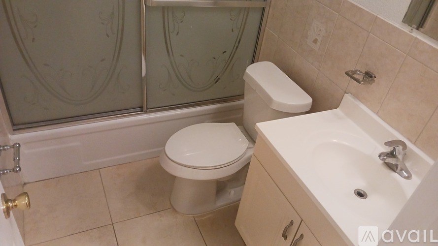 A bathroom with a toilet, sink, and shower.