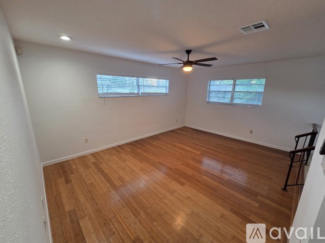 A room with wooden flooring and a ceiling fan.