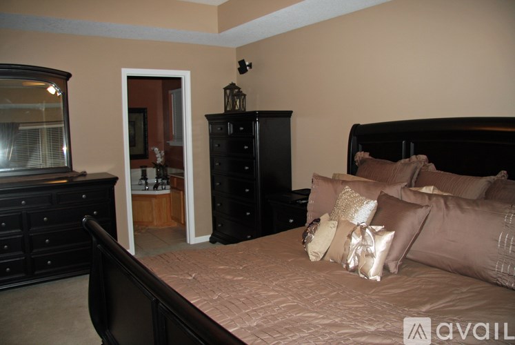 A bedroom with a bed, dresser, and mirror.