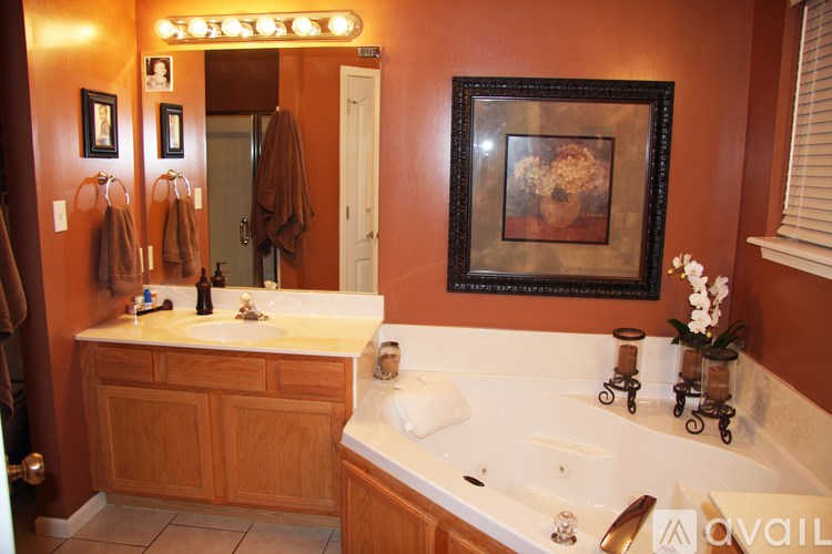 A bathroom with a brown wall and a white tub.