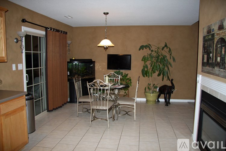 A kitchen with a table and chairs and a television.