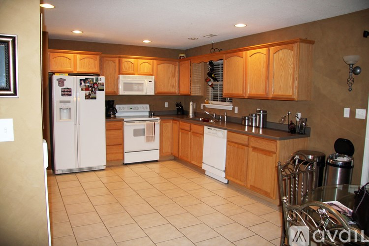 A kitchen with wooden cabinets and white appliances.