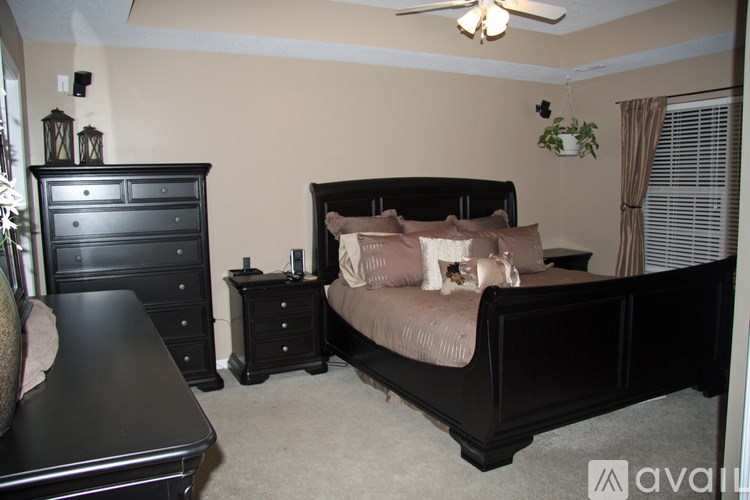 A bedroom with a bed, dresser, and nightstand.