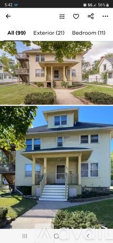 A two-story house with a front porch and a balcony on the second floor.