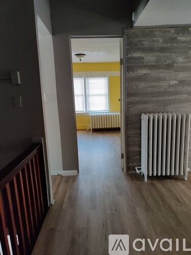 A room with wooden floors and a white radiator.