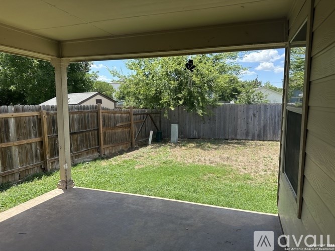 A backyard with a wooden fence and a green lawn.