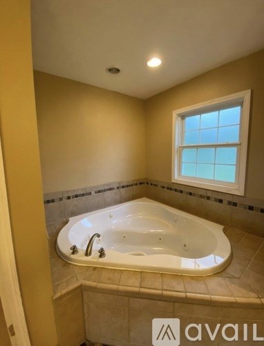 A bathroom with a tub and a window.