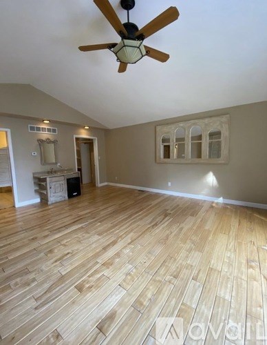 A room with wooden flooring and a ceiling fan.