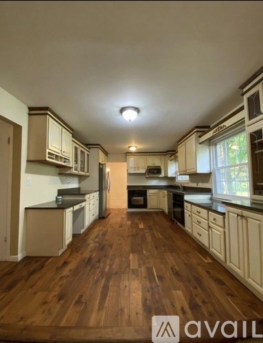 A kitchen with wooden floors and white cabinets.