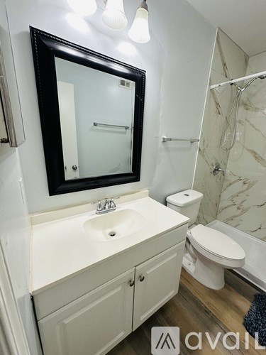 A bathroom with a sink, toilet and mirror.