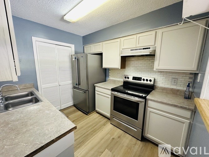 A kitchen with a sink, stove, and refrigerator.