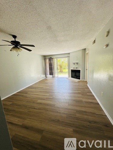A room with a ceiling fan and wooden flooring.