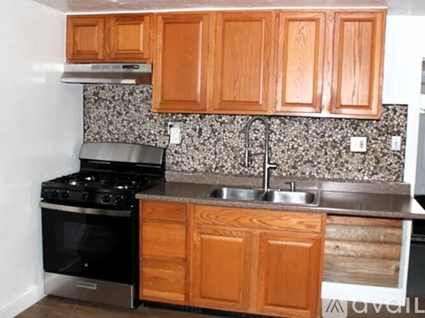 A kitchen with wooden cabinets and a black stove top oven.