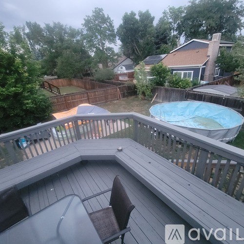 A deck with a hot tub and a chair.
