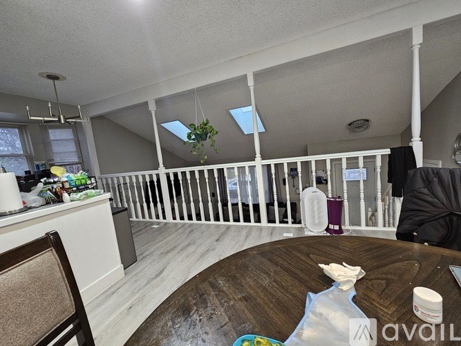 A living room with a white railing and a wooden table.