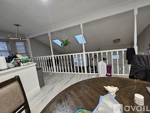 A living room with a white railing and a wooden table.