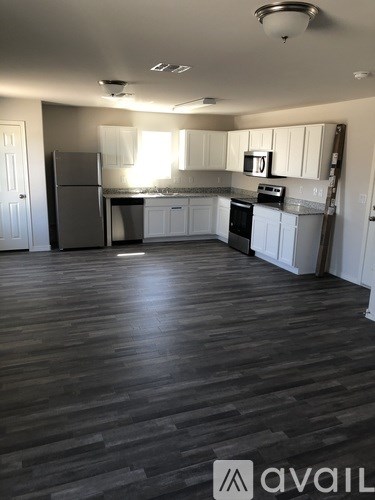 A kitchen with a refrigerator, oven, and microwave.