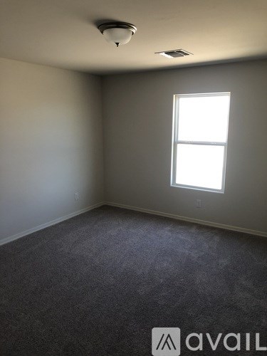 A room with a window and carpeted floor.