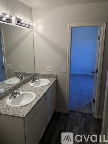 A bathroom with two sinks and a mirror.