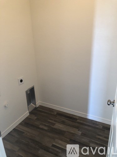 A room with a wooden floor and a door.