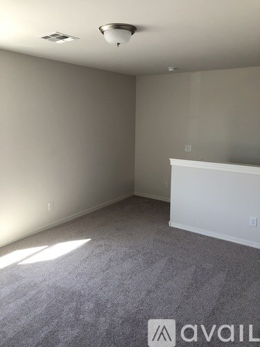 A room with a carpeted floor and a white fireplace.