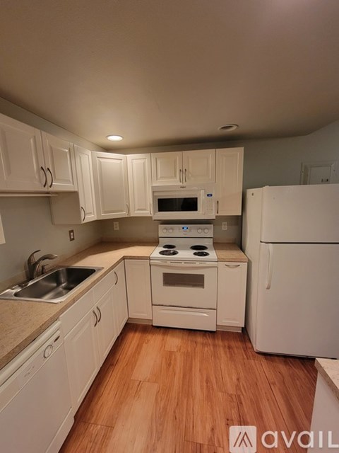 A kitchen with white cabinets and appliances.