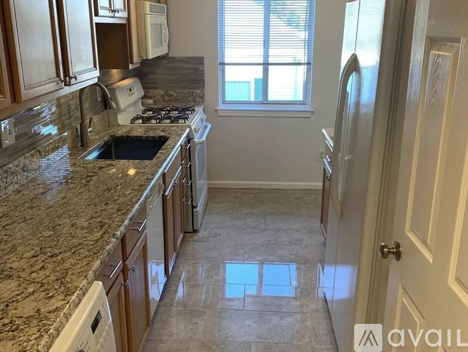 A kitchen with granite countertops and a tile floor.