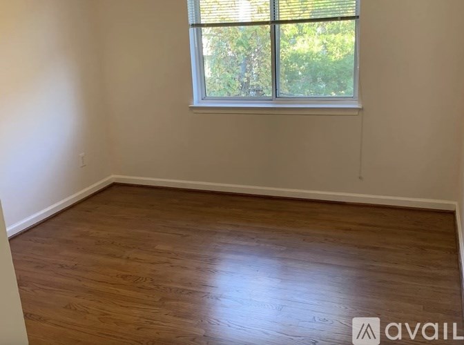 A room with wooden flooring and a window.