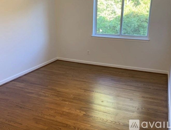 A room with wooden flooring and a window.