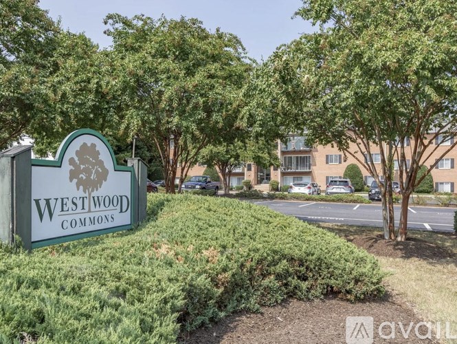 A sign for Westwood Commons is in front of a building and trees.