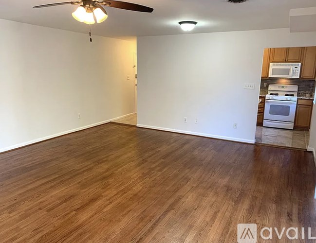 A room with wooden flooring and a ceiling fan.