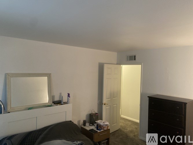 A bedroom with a bed, dresser, and mirror.