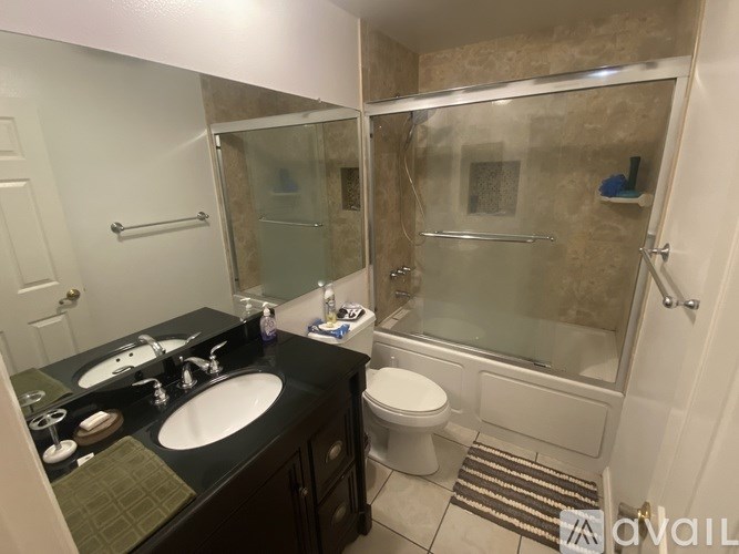A bathroom with a black vanity and a walk-in shower.