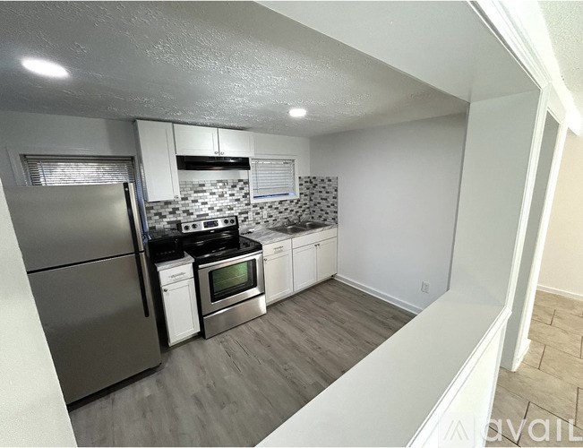 A kitchen with a refrigerator, oven, and microwave.