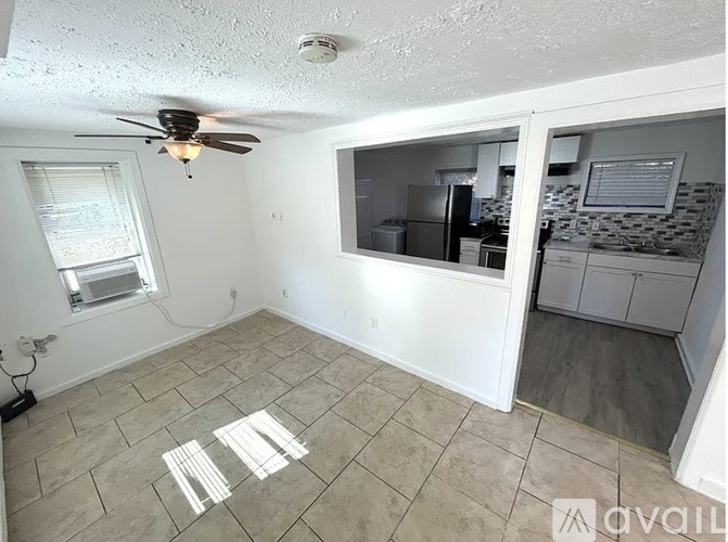 A room with a ceiling fan and a window.