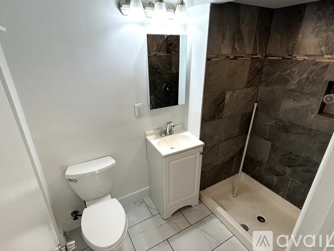 A white toilet sits next to a sink in a bathroom.